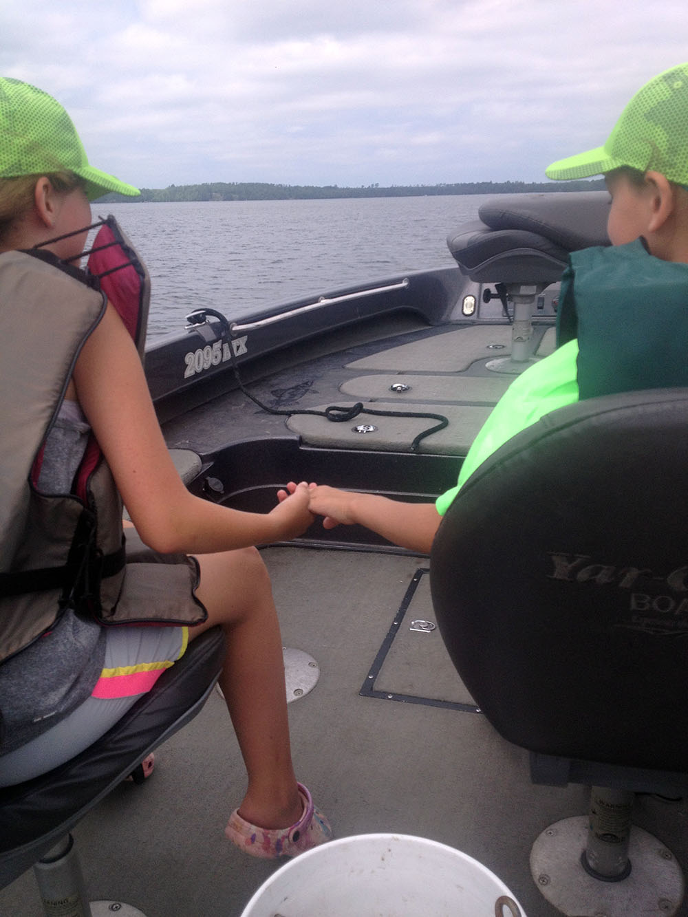 Girl and boy riding in fishing boat
